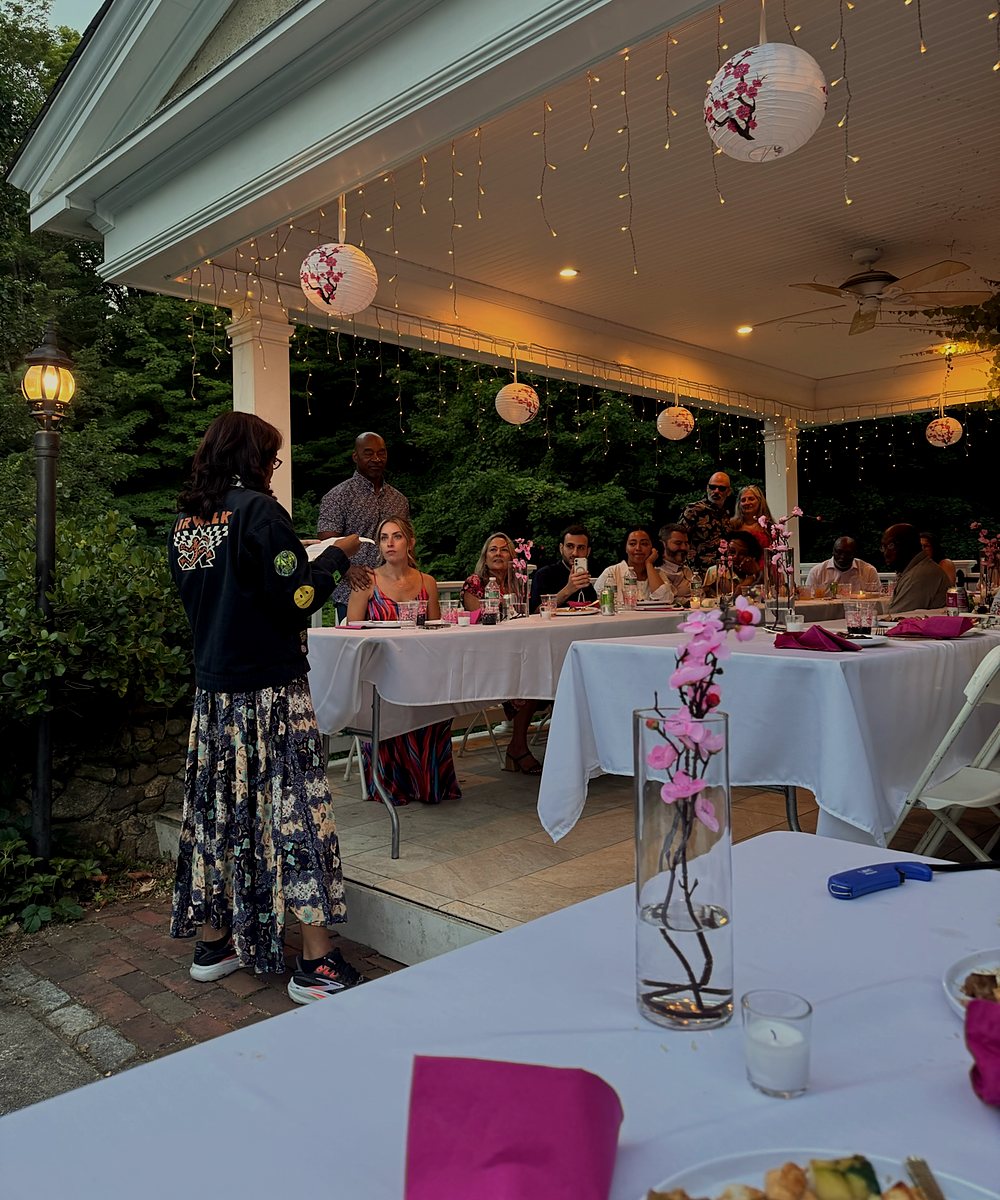 Guests at a lantern-lit covered patio dinner during a private hibachi party